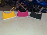 three purses sitting on a table next to a motorcycle