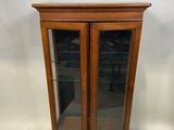 une vitrine en bois avec des portes vitrées et une porte vitrée