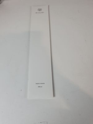 Quelqu'un tient un marque-page blanc sur une table blanche.