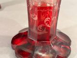 a red glass vase with a picture of a woman on it