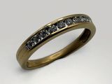 a close up of a gold ring with black and white diamonds