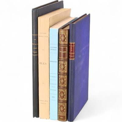 trois livres sont empilés sur une surface blanche