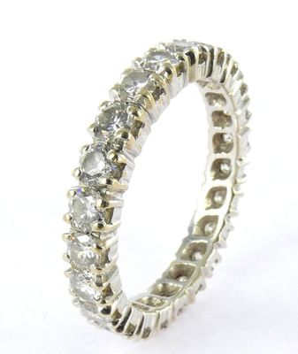 a close up of a diamond ring on a white surface