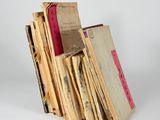 several old books stacked on top of each other on a white surface
