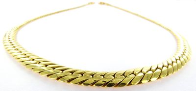 a gold necklace on a white background