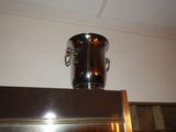 a silver vase on top of a refrigerator in a kitchen