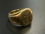 an image of a gold signet ring on a black surface