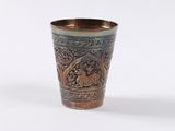 a shot glass with a design on it on a white surface