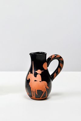 un vase noir et orange orné d'un cheval