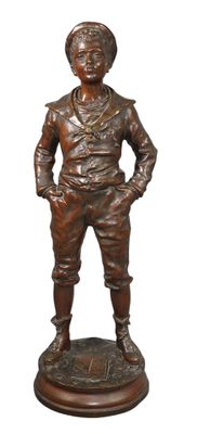 statue en bronze représentant un garçon debout sur un socle, les mains dans les poches