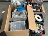 une boîte remplie d'objets hétéroclites posée sur le sol