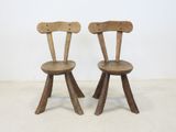 two wooden chairs sitting next to each other on a white floor