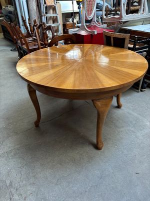 une table en bois entourée de chaises dans un entrepôt