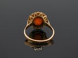 an old gold ring with an orange stone in the center