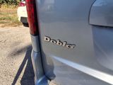 the back end of a silver truck with a dobie logo on it ' s side