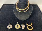 a hat, necklace and earrings are on display in a display case