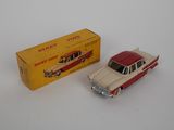 a red and white toy car next to a yellow box