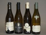 quatre bouteilles de vin sont alignées sur une table
