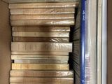 de nombreux livres dans une boîte en carton posée sur une étagère