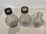 trois bouteilles en verre vides posées sur une table