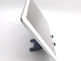 a tablet computer sitting on a stand on a white surface