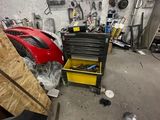 un garage rempli d'outils et d'une voiture de sport rouge
