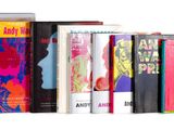 several books are lined up in a row on a white surface