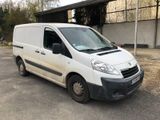 la camionnette blanche est garée devant un bâtiment dans un parking