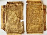 two pieces of gold are shown on a white surface