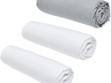 trois rouleaux de serviettes blanches posés les uns à côté des autres sur une surface blanche