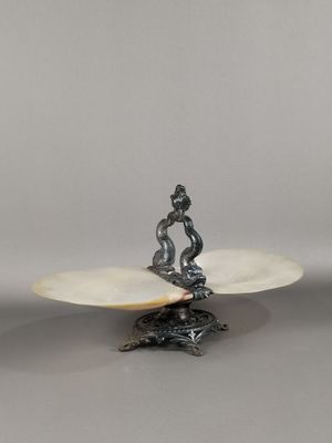 un plateau en argent sur lequel est posé un oiseau, posé sur une table