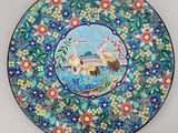 a close up of a decorative plate with birds and flowers on it
