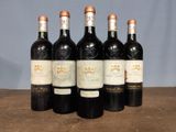 six bottles of wine are lined up on a wooden table