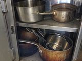 pots and pans are sitting on a shelf in a kitchen