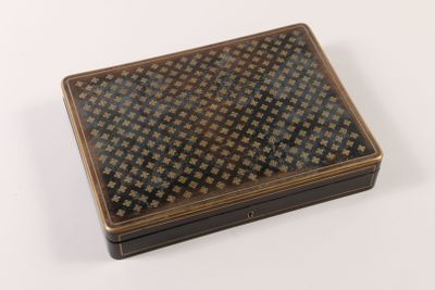 une boîte marron et une boîte noire sur un fond blanc à motifs