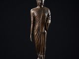 une statue en bronze représentant une personne debout sur un socle