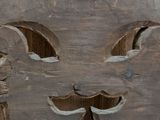 a wooden carving of a face on the side of a building