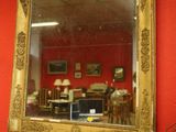 a mirror hanging on a red wall in a room