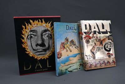trois livres sont empilés sur une surface grise