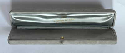an image of a silver box with a gold ring inside of it