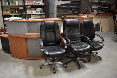 deux fauteuils de bureau en cuir noir placés devant un bureau