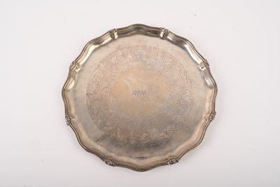 un plat en argent ancien posé sur une table blanche, sur fond blanc