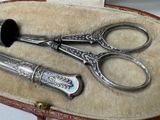two pairs of scissors in a case on a table