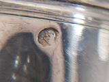 a close up of a silver plate with a hole in it