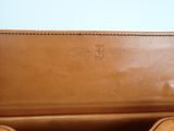 a close up of a brown leather bag on a table