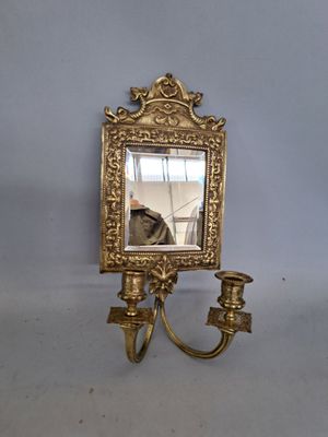 un miroir accroché au mur et un bougeoir accroché au mur