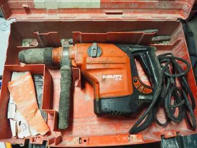 une boîte à outils orange contenant un marteau et d'autres outils