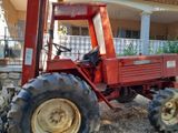 a red tractor that is parked in front of a house