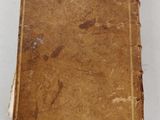 an old book sitting on top of a white table covered in dirt