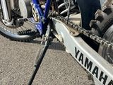 a blue dirt bike parked on the side of the road